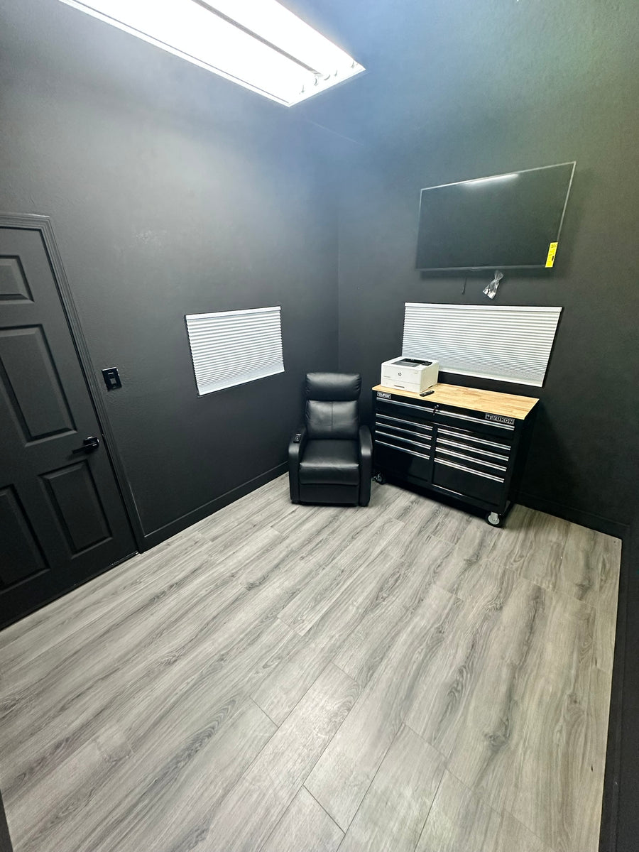 Private room with client chair and TV at Tagz Tattoo