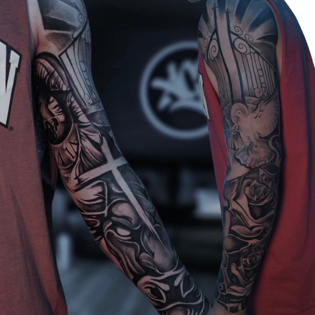 Two black and grey full arm sleeves, an armored figure with a large cross and a tall gate with a dove and roses, Tagz Tattoo in Mesa, AZ