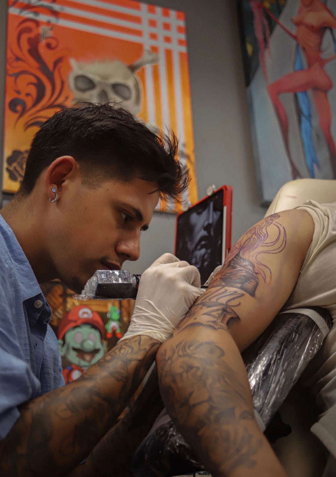 Artist working on a client's forearm at Tagz Tattoo in Mesa