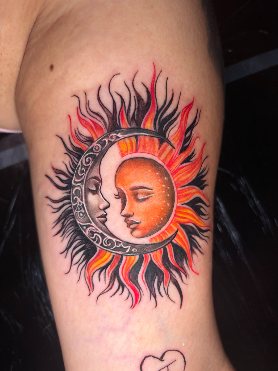 Color sun and crescent moon tattoo on the upper arm, done at Tagz Tattoo in Mesa, AZ