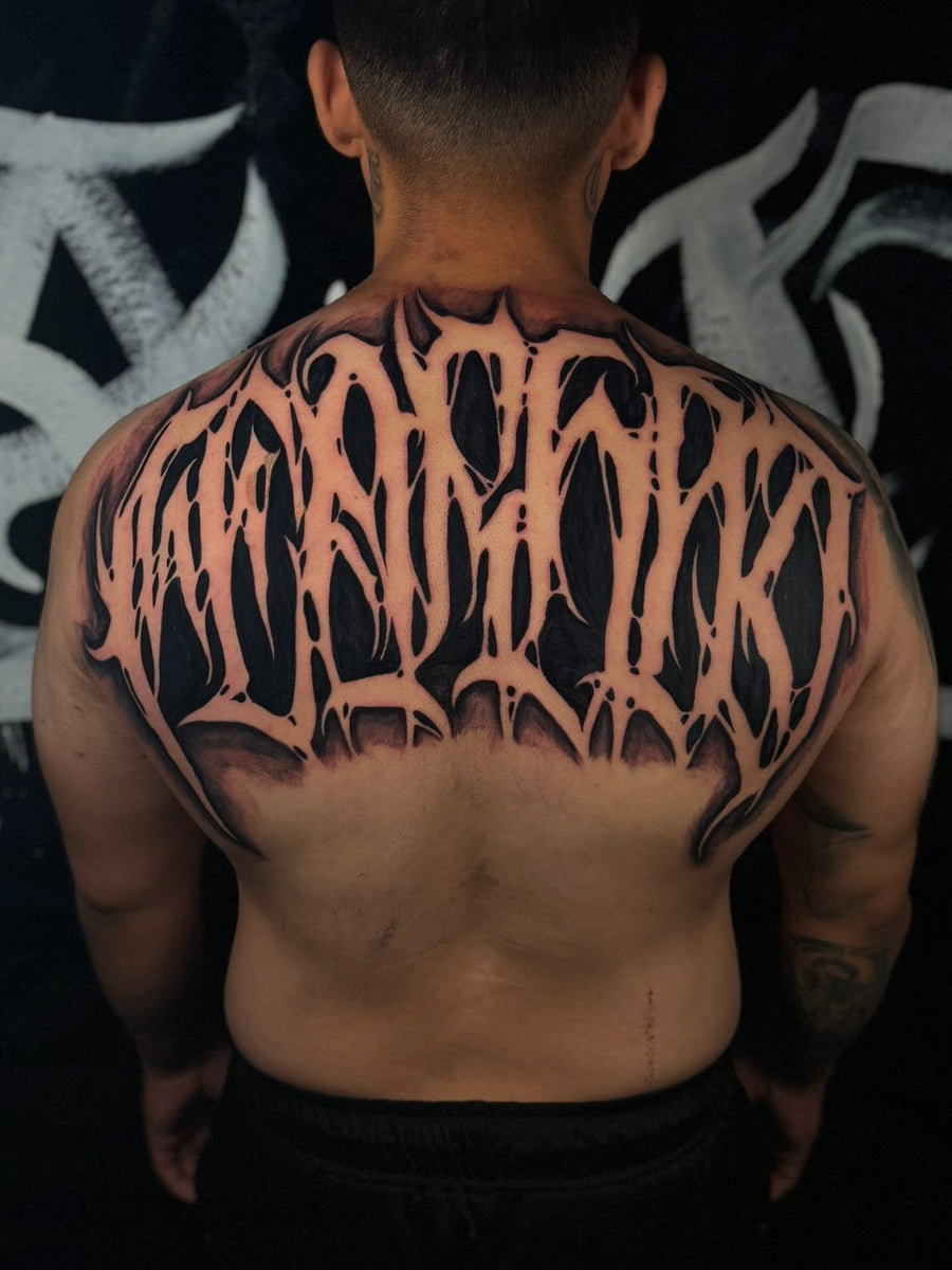 Custom lettering upper back tattoo