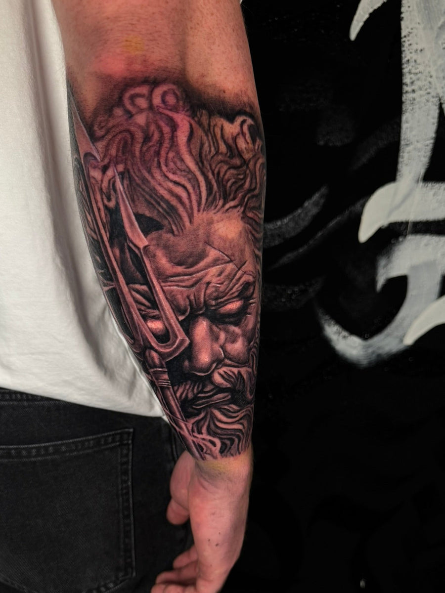 Black and grey Greek god forearm tattoo
