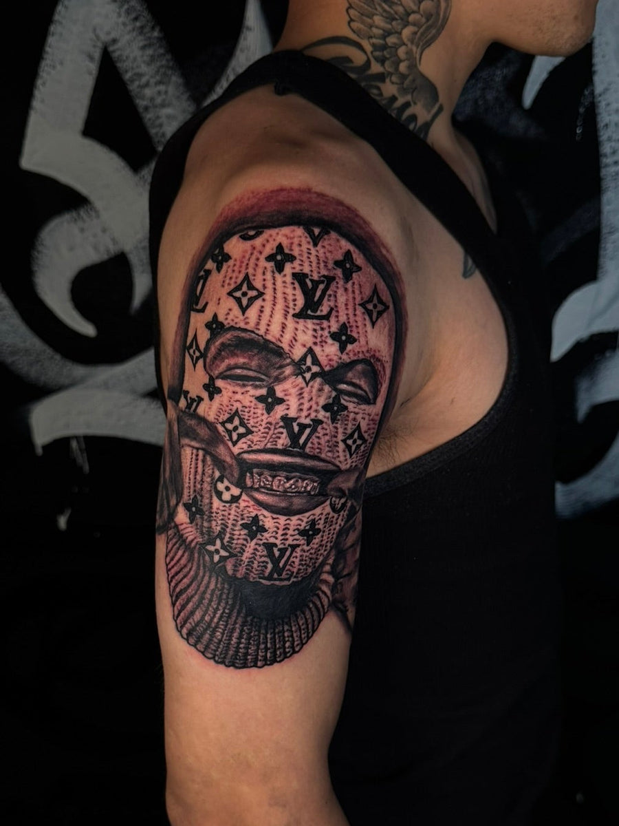 Black and grey pattern and skull shoulder tattoo
