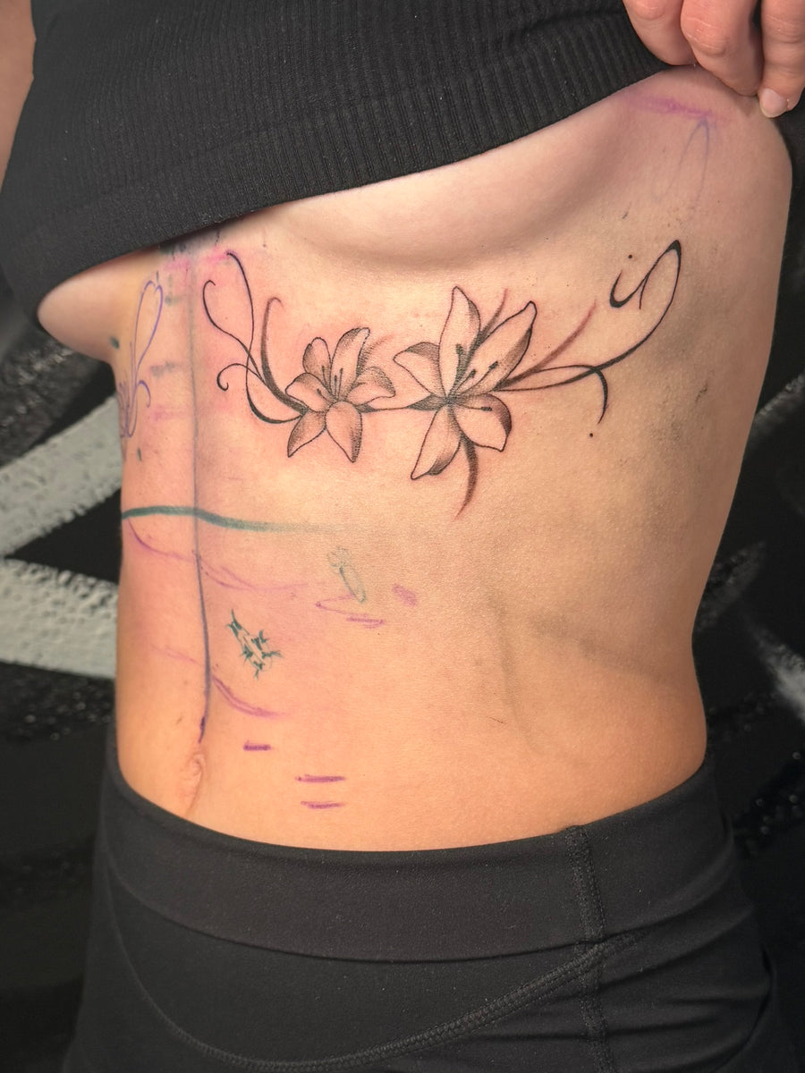 Fine line floral rib tattoo