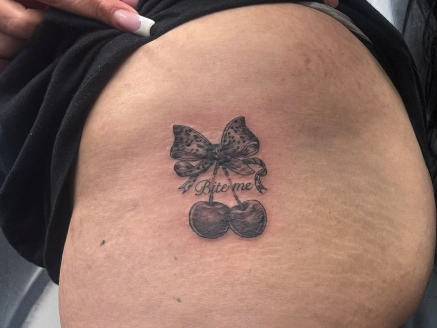 Fine line bow and cherries tattoo