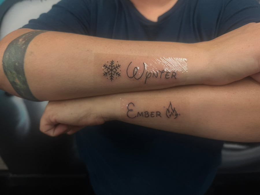 Fine line script names forearm tattoo