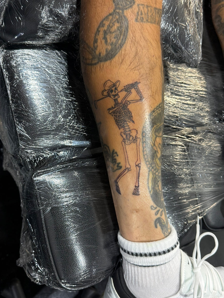 Fine line skeleton cowboy leg tattoo