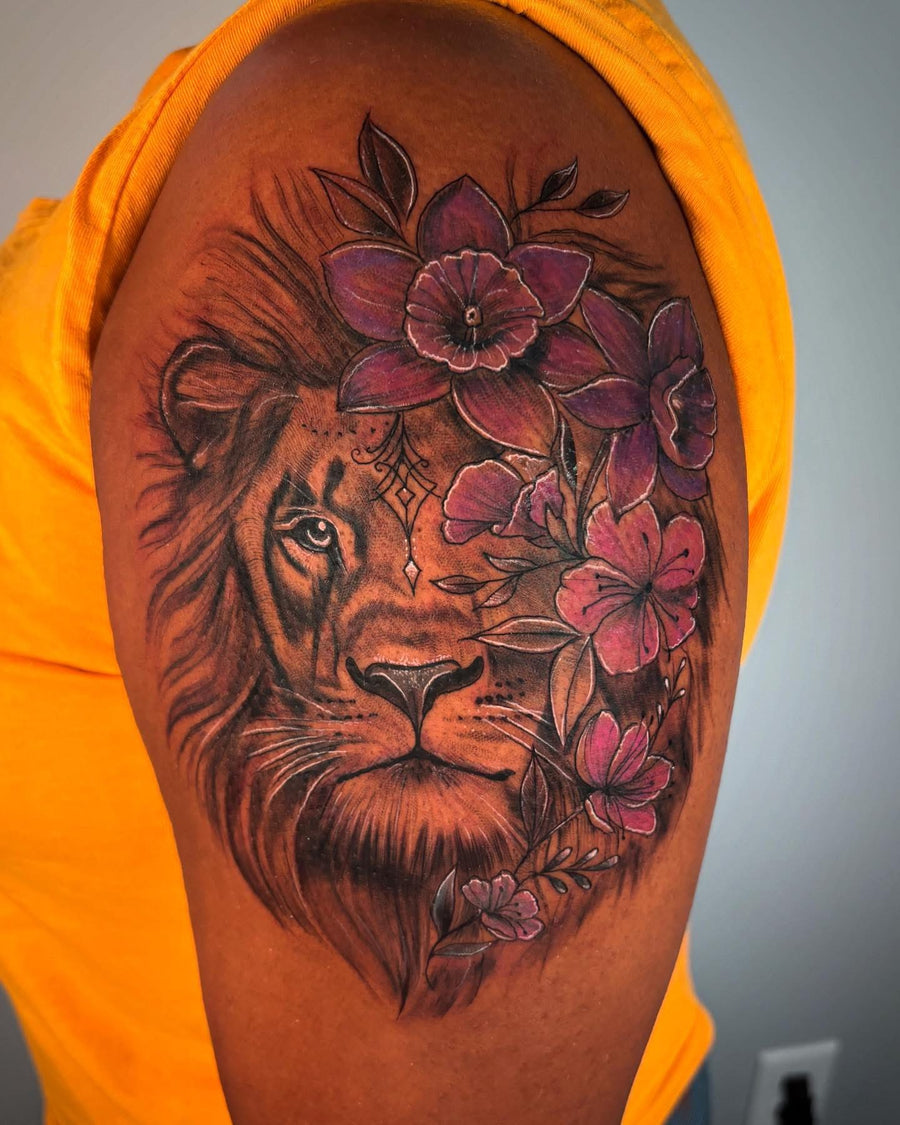 Color lion and flowers tattoo on the upper arm, done at Tagz Tattoo in Mesa, AZ