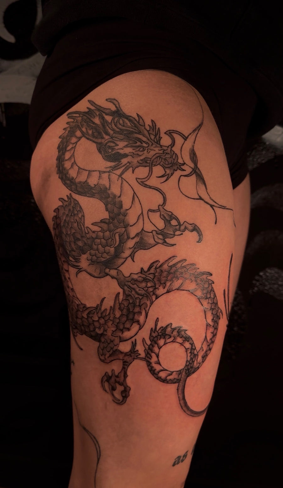 Fine line dragon thigh tattoo