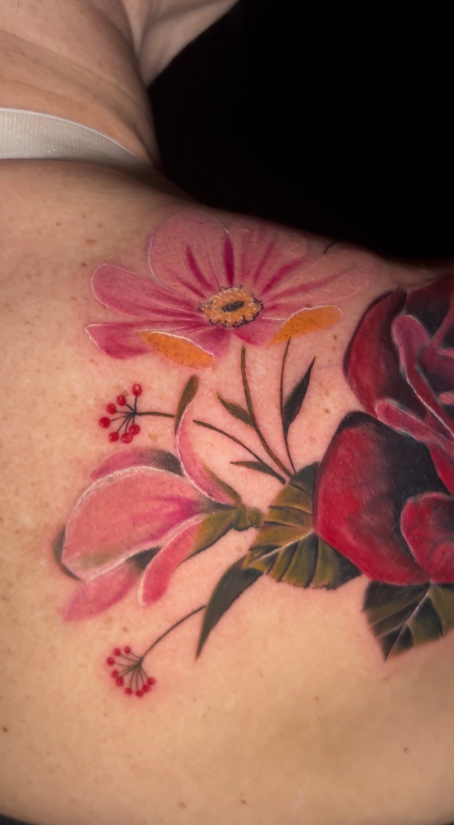 Color floral shoulder tattoo with pink and red blooms