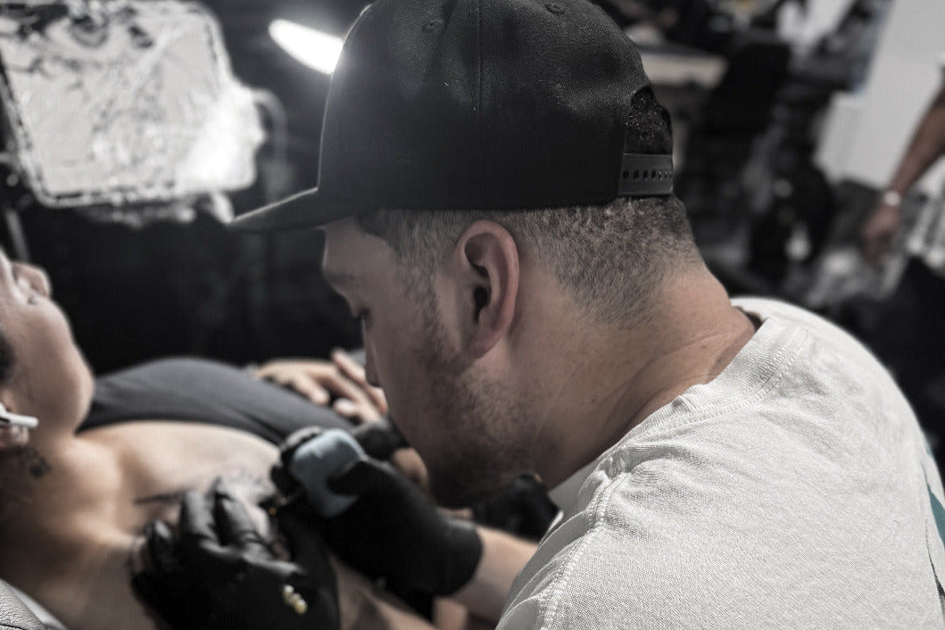 Tattoo artist working on a client at Tagz Tattoo Mesa